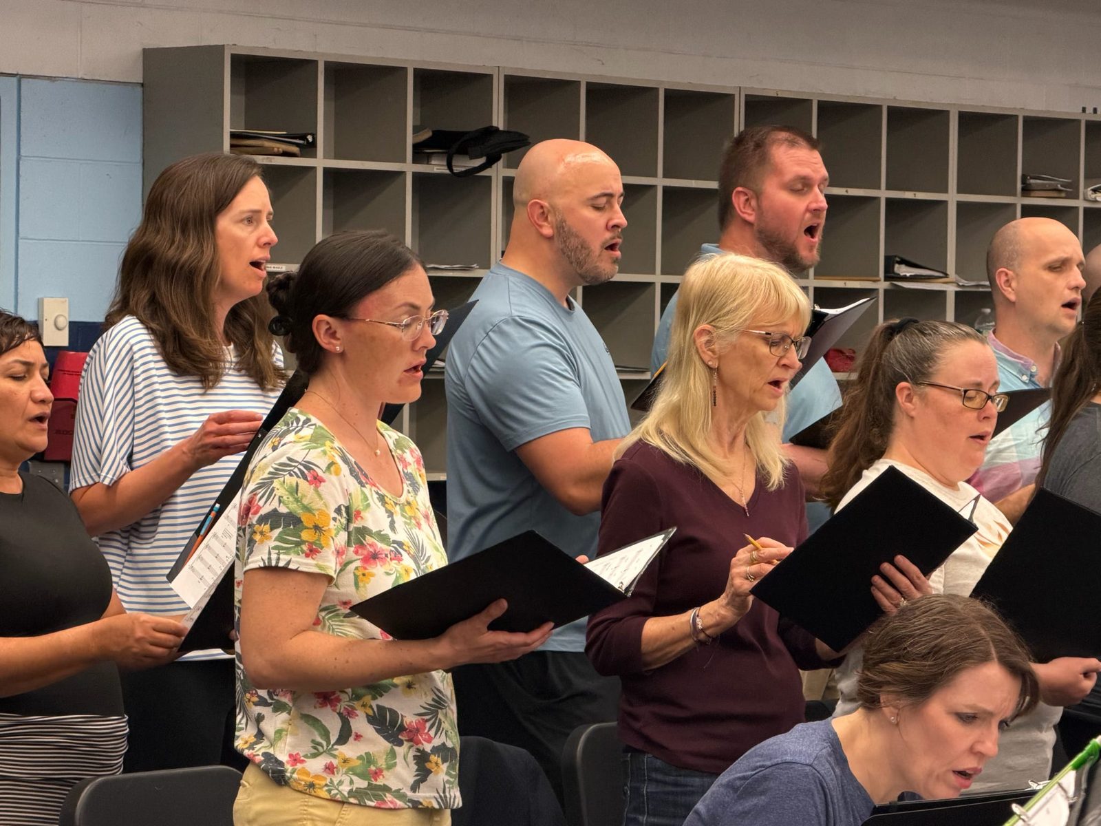Choir members of different ages singing together in rehearsal