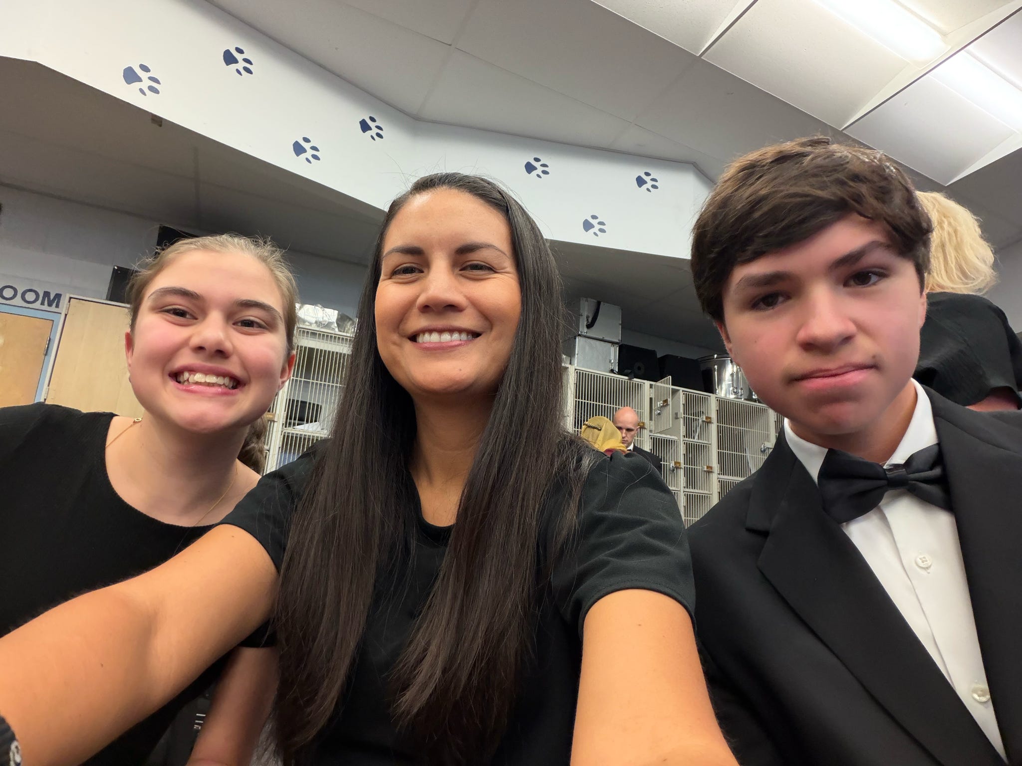 Three performers in concert black smiling together