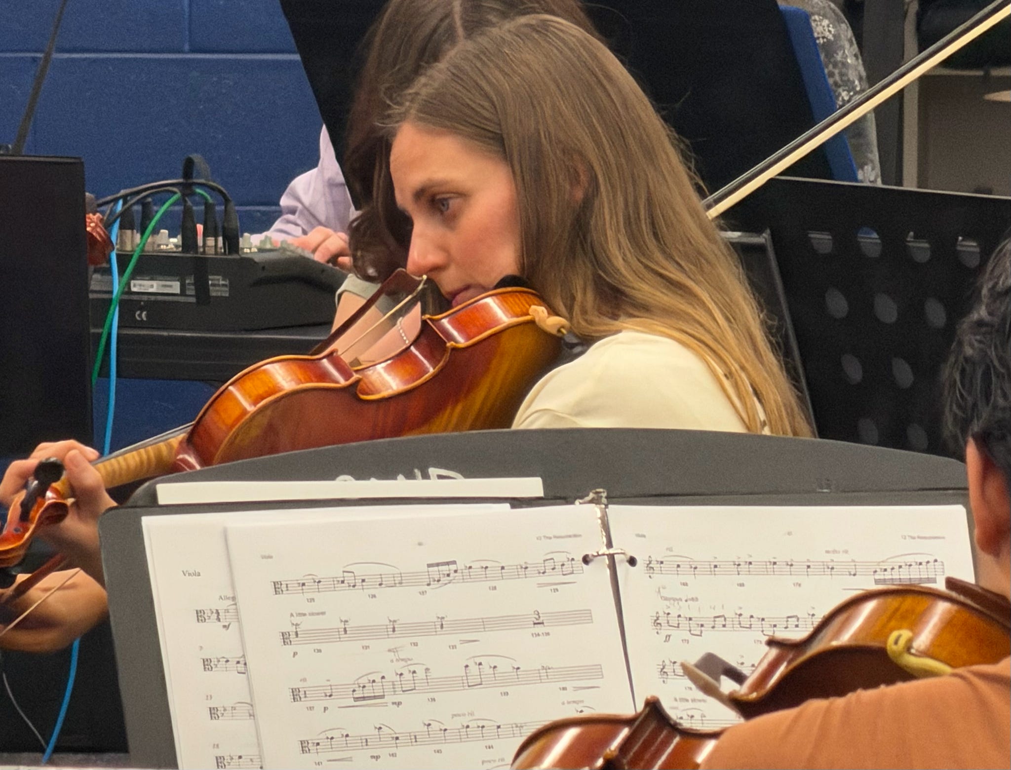 A violist reading her part during rehearsal